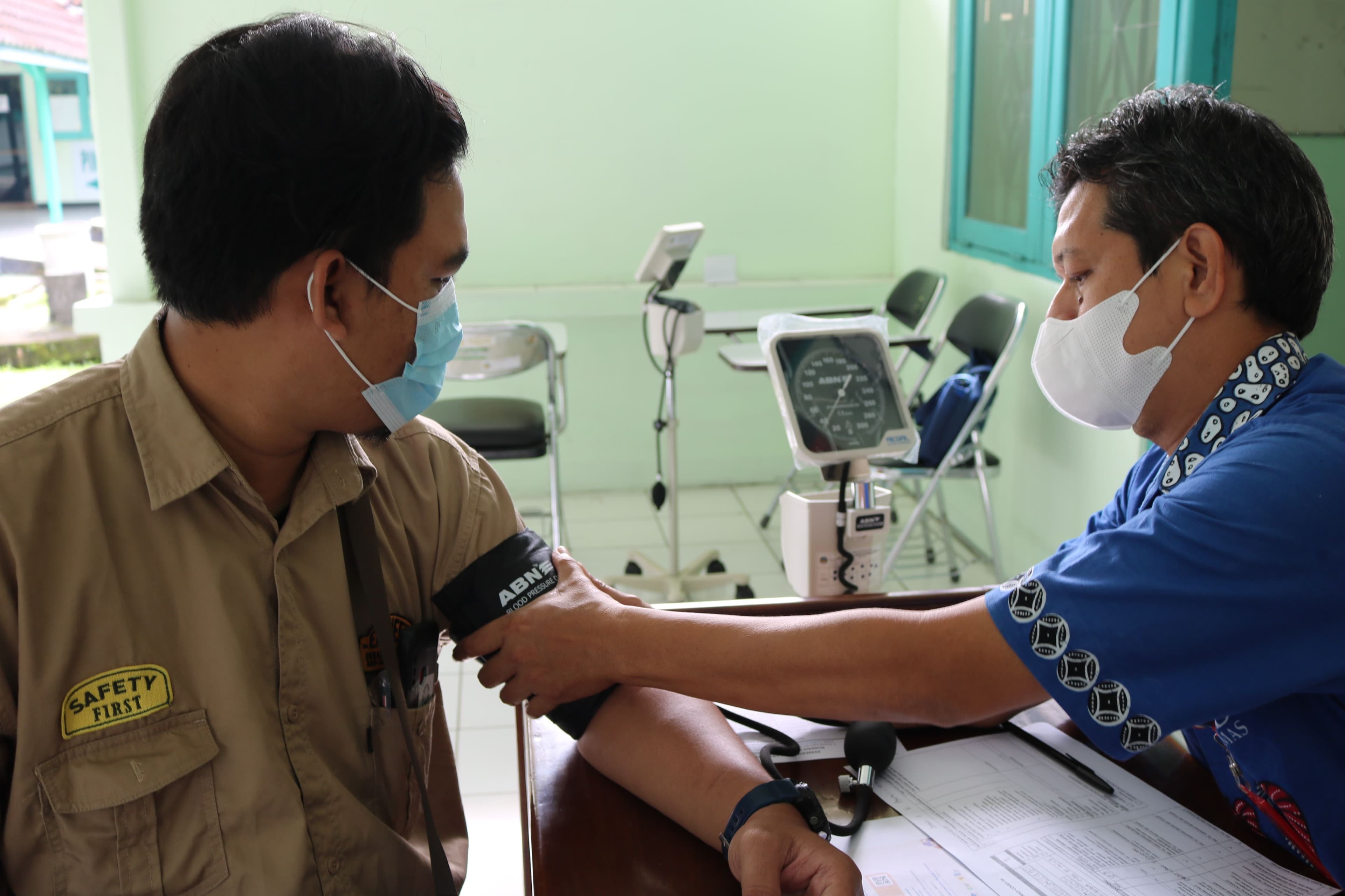 Provider checking a worker's blood pressure during a DOT physical exam
